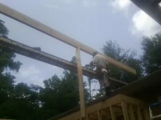 Carpenter setting a ridge beam over a new addition frame — Ice Dam Removal by Roofing Brothers in Mohegan Lake