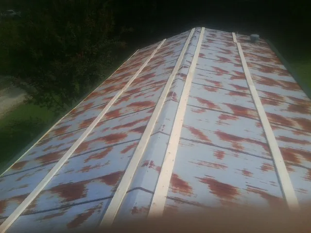 Rusted metal roof panels with new wood purlins before replacement — Storm Damage Roof Repair in Mohegan Lake by Roofing Brothers
