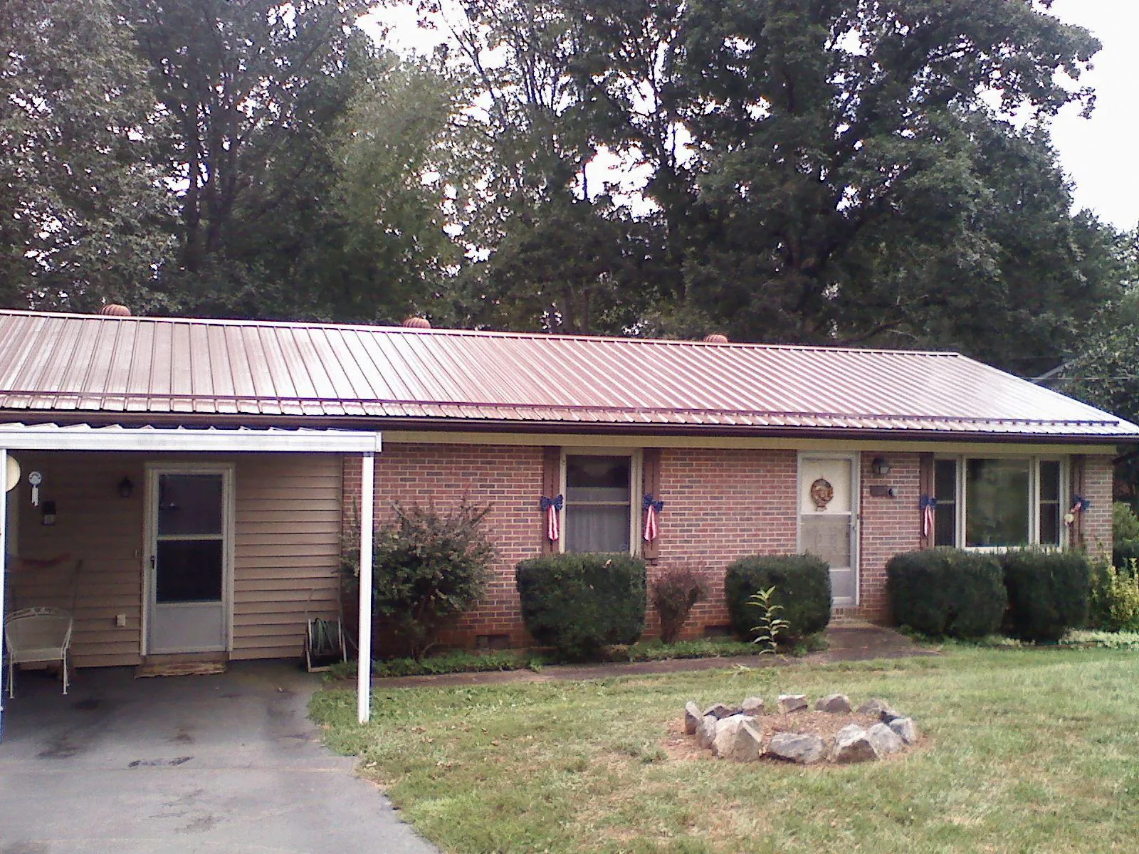 Bronze metal roof and carport on a brick ranch home — Roof Repair work by our crew in Mohegan Lake